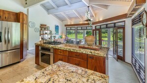 A spacious kitchen with a large island, built-in appliances, and a view to the outdoors. - Kolohala in Haena is a tranquil place to enjoy your tropical vacation! (Haena)
