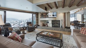 A spacious living room with a fireplace, comfortable seating, and a large TV. - Ski in/Out 7th Floor Penthouse at Purg - Huge Deck w/ Mountain/Slope Views/AC (Durango)