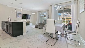 Una cocina moderna con comedor, televisor y balcón con vistas.