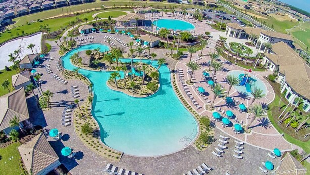 Un resort con varias piscinas, tumbonas y palmeras.