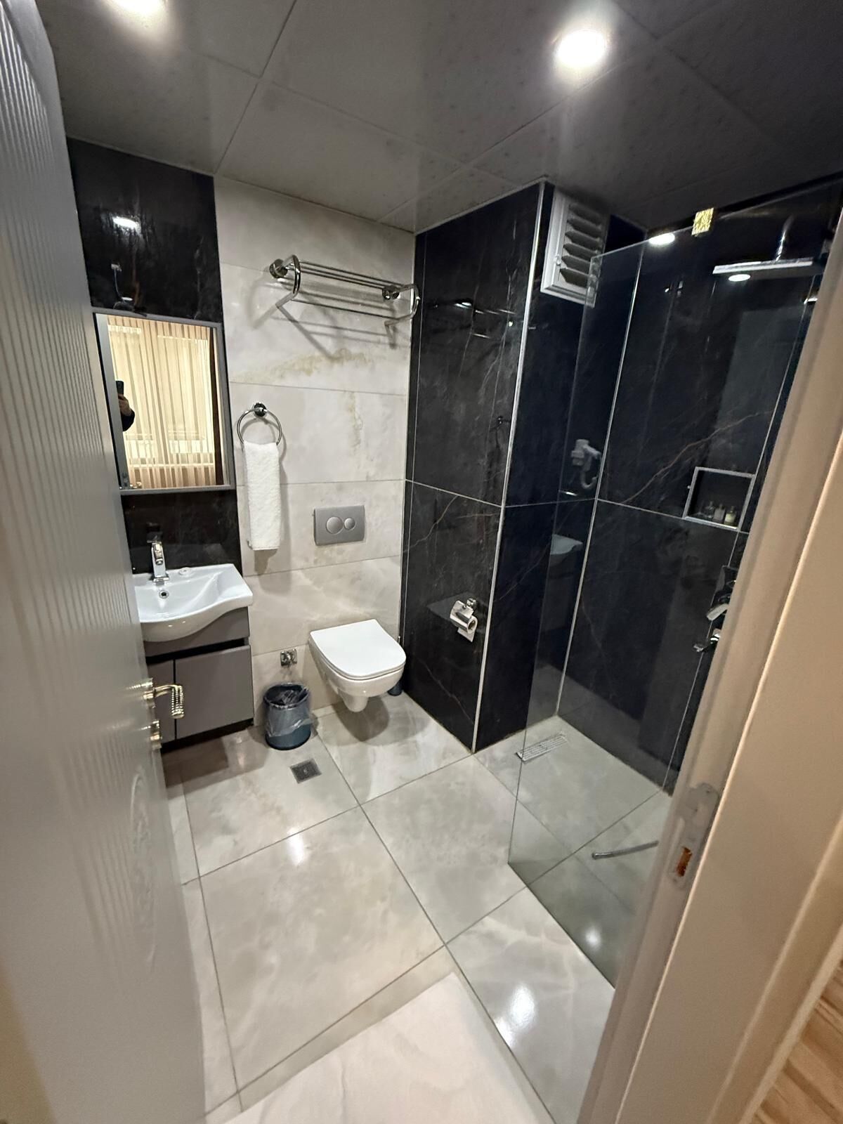 Une salle de bain moderne équipée de toilettes, d’un lavabo et d’une zone douche.
