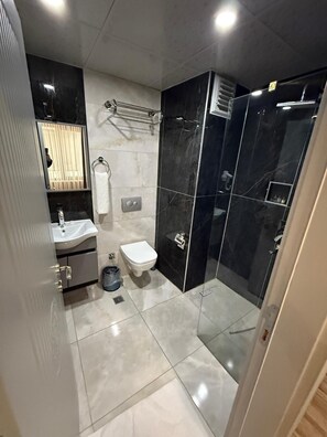 A modern bathroom with a toilet, sink, and shower area. - WORLD SAY HOTEL (Van)