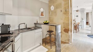 Una cocina moderna con encimera de mármol, electrodomésticos de acero inoxidable y una zona de bar con taburetes.