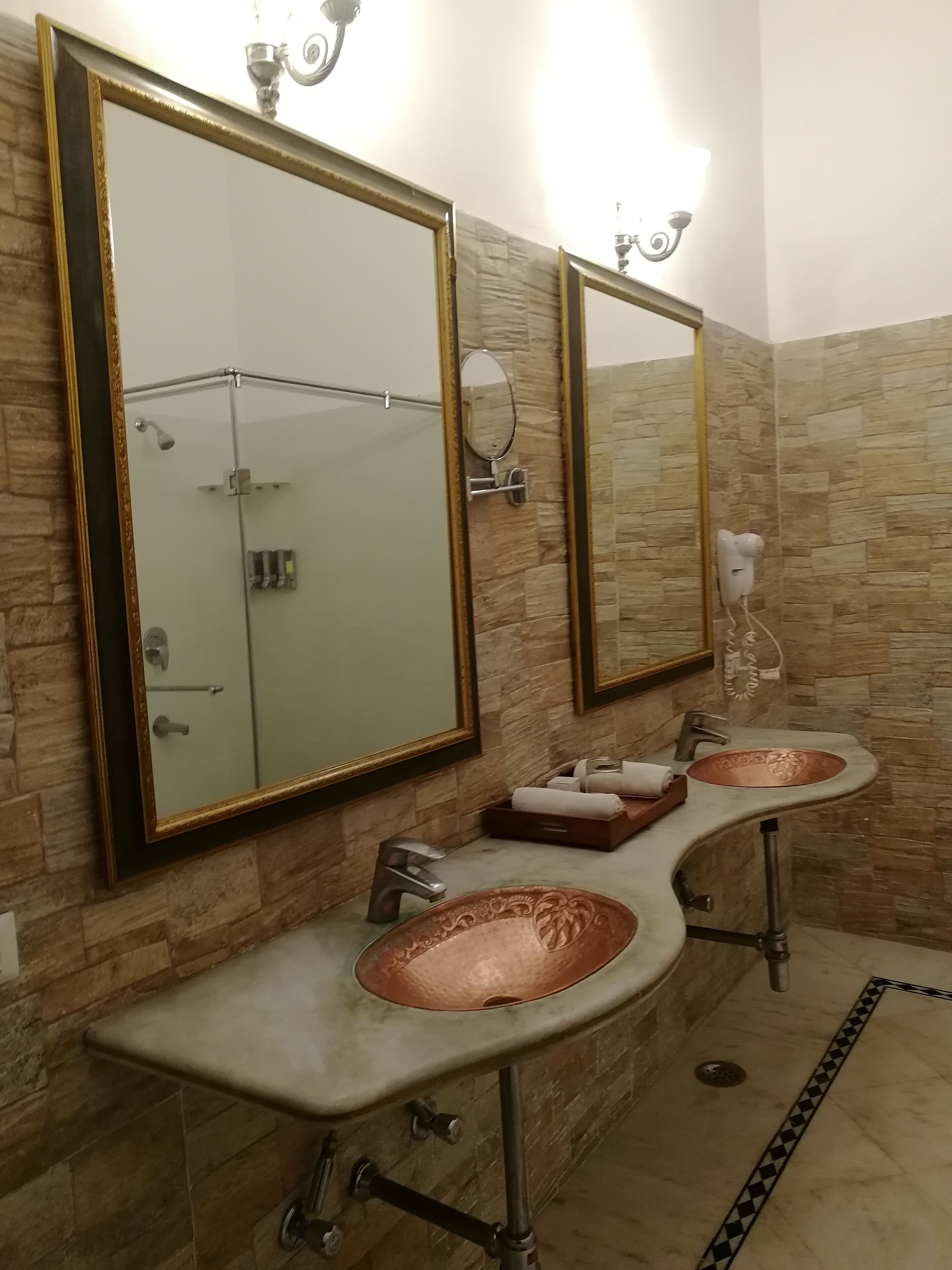 A bathroom with two sinks, a large mirror, and a shower.