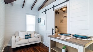 A cozy room with a sofa, a wooden table, and a sliding barn door. - Casa De Moya & Mistico Beach Club + Boat Shuttle (San Pedro)
