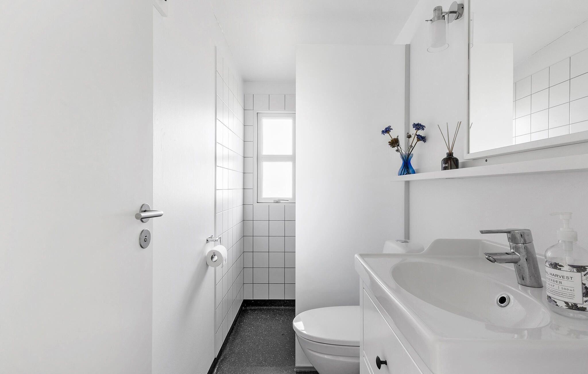Un baño moderno con inodoro, lavamanos y espejo.