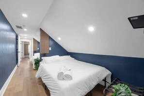 Um quarto com uma cama, uma mesinha e um vaso de planta.