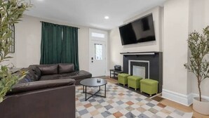 A living room with a sofa, a coffee table, and a fireplace. - Spacious 5-Bedroom Home with Hot Tub (Columbus)