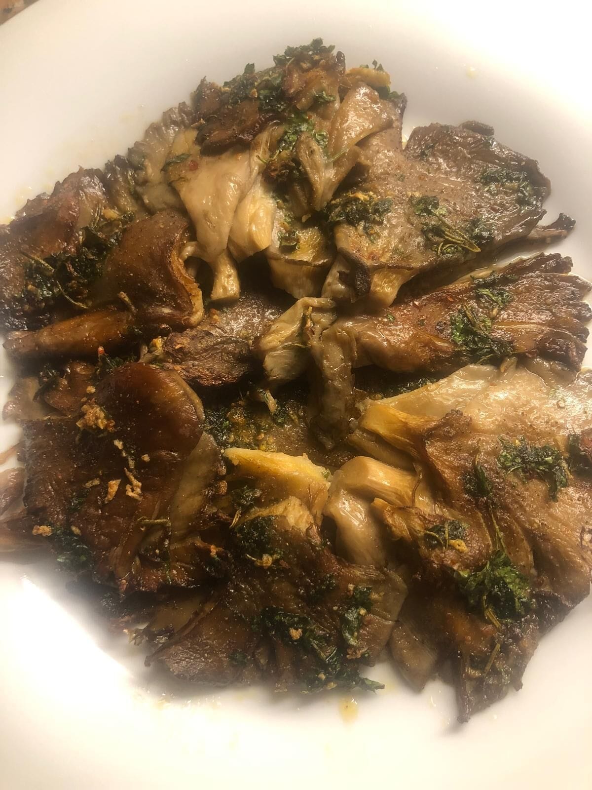Un plato de carne cocinada con verduras y hierbas.