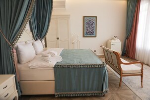 Un dormitorio con cama, una silla, un armario y una obra de arte enmarcada en la pared.