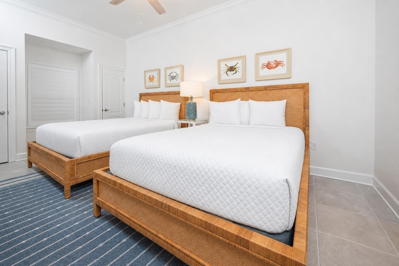 A double bed with a wooden frame and white bedding, a bedside table with a lamp, and framed pictures on the wall.