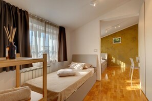 A modern bedroom with a single bed, a small table with a bottle of reed diffuser, and a chair. - Villa Nata in Pula - Haus für 8 Personen (Pula)