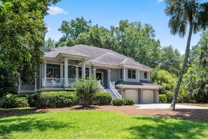 A two-story house with a covered porch, a garage, and a well-maintained lawn.
