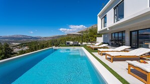 A modern poolside area with a clear view of the mountains in the background.