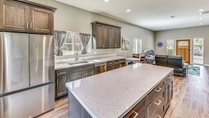 A spacious kitchen with a large island, stainless steel appliances, and dark wooden cabinets. - Peaceful Riverside Home w/ Patio, 7 Mi to Downtown (Riverside)