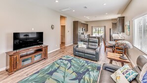 A spacious living room with a flat-screen TV, leather sofa, and a dining area with a table and chairs. - Peaceful Riverside Home w/ Patio, 7 Mi to Downtown (Riverside)