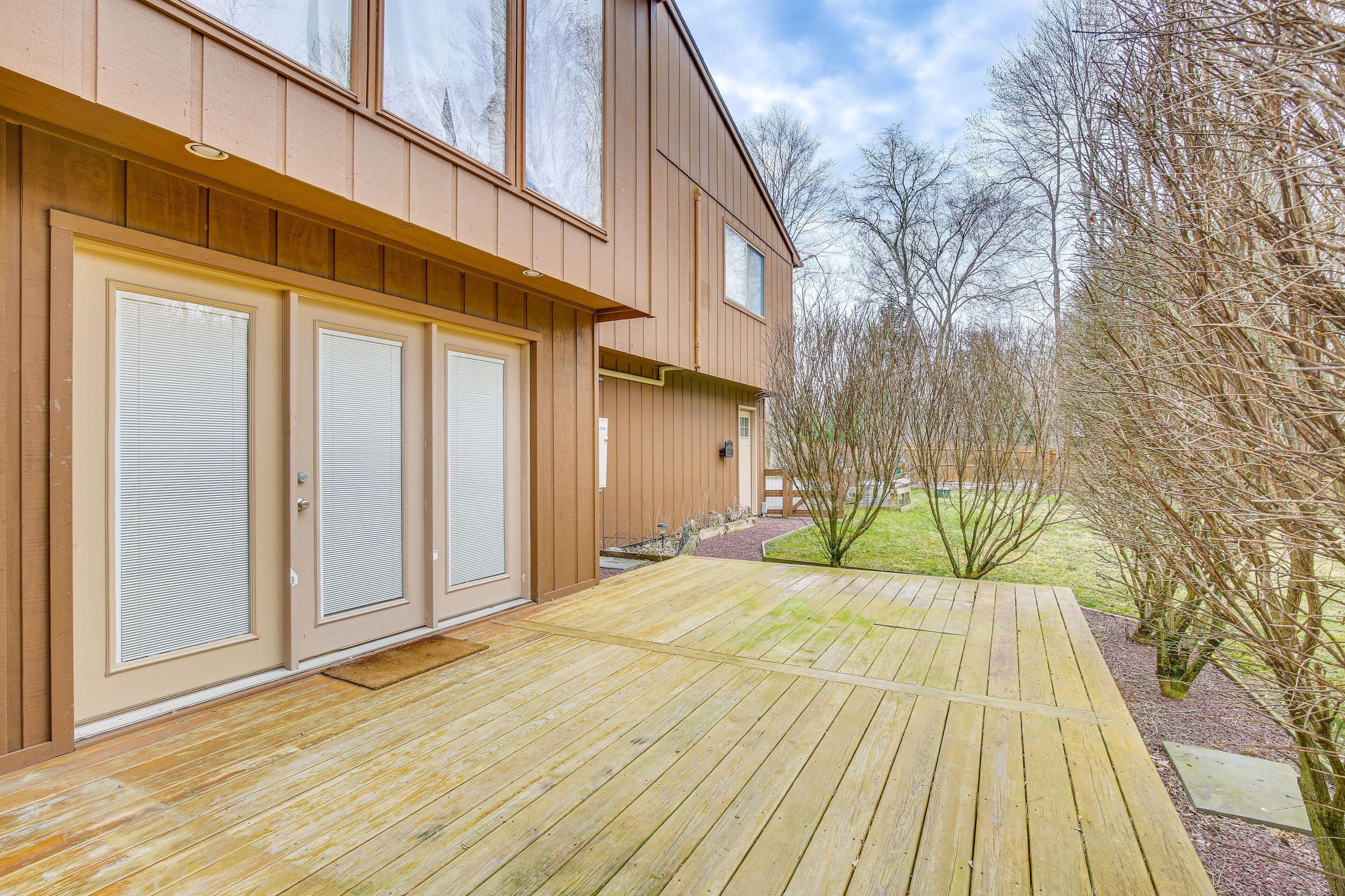 A modern building with a wooden deck and a small garden area.