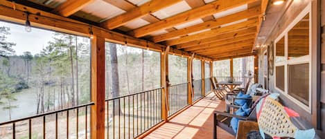 A wooden deck with a railing, a table, and a fish sculpture.