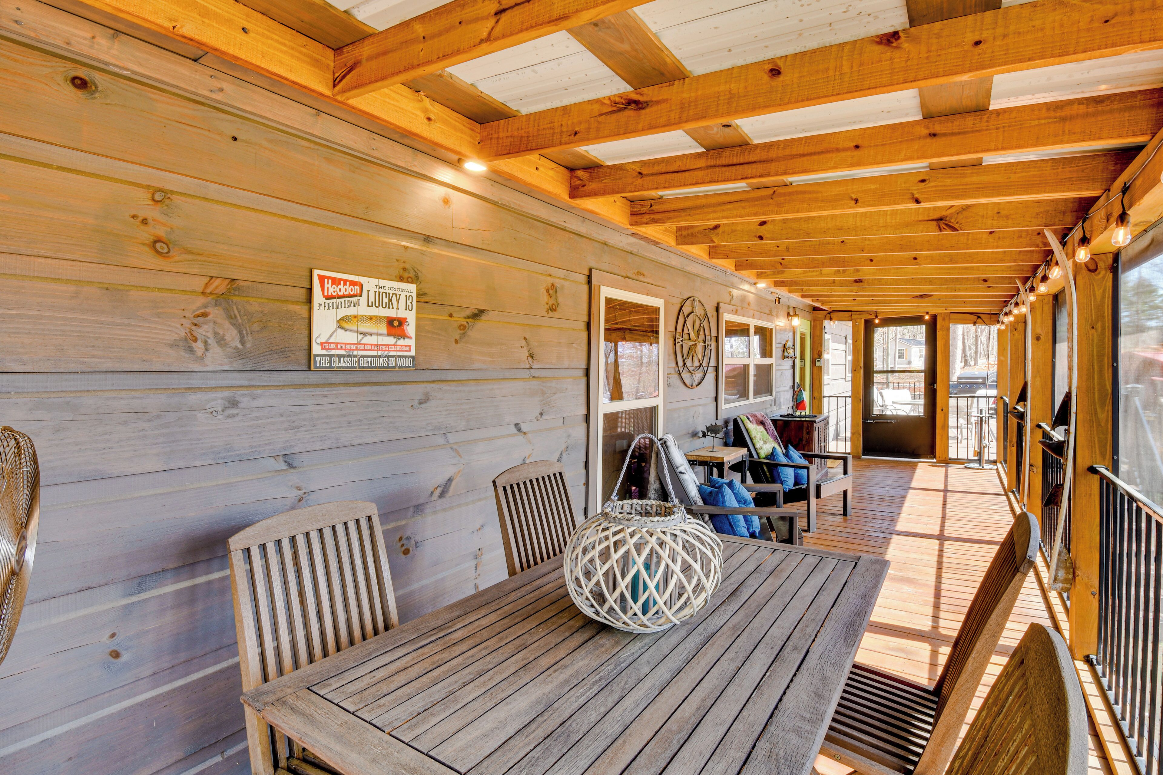 A wooden deck with a table and chairs, a wicker basket, and a sign on the wall.