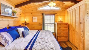 A cozy wooden cabin bedroom with a bed, dresser, and ceiling fan. - Waterfront Seneca Cabin ~ 4 Mi to Boat Launch! (Seneca)