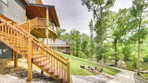 A wooden staircase leading to a deck, a concrete pathway, and a lake view. - Modern Lake House Retreat w/ Deck on Pickwick Lake (Counce)