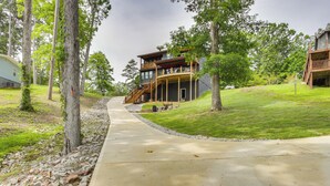 A two-story house with a wooden deck and a stone pathway leading to it. - Modern Lake House Retreat w/ Deck on Pickwick Lake (Counce)