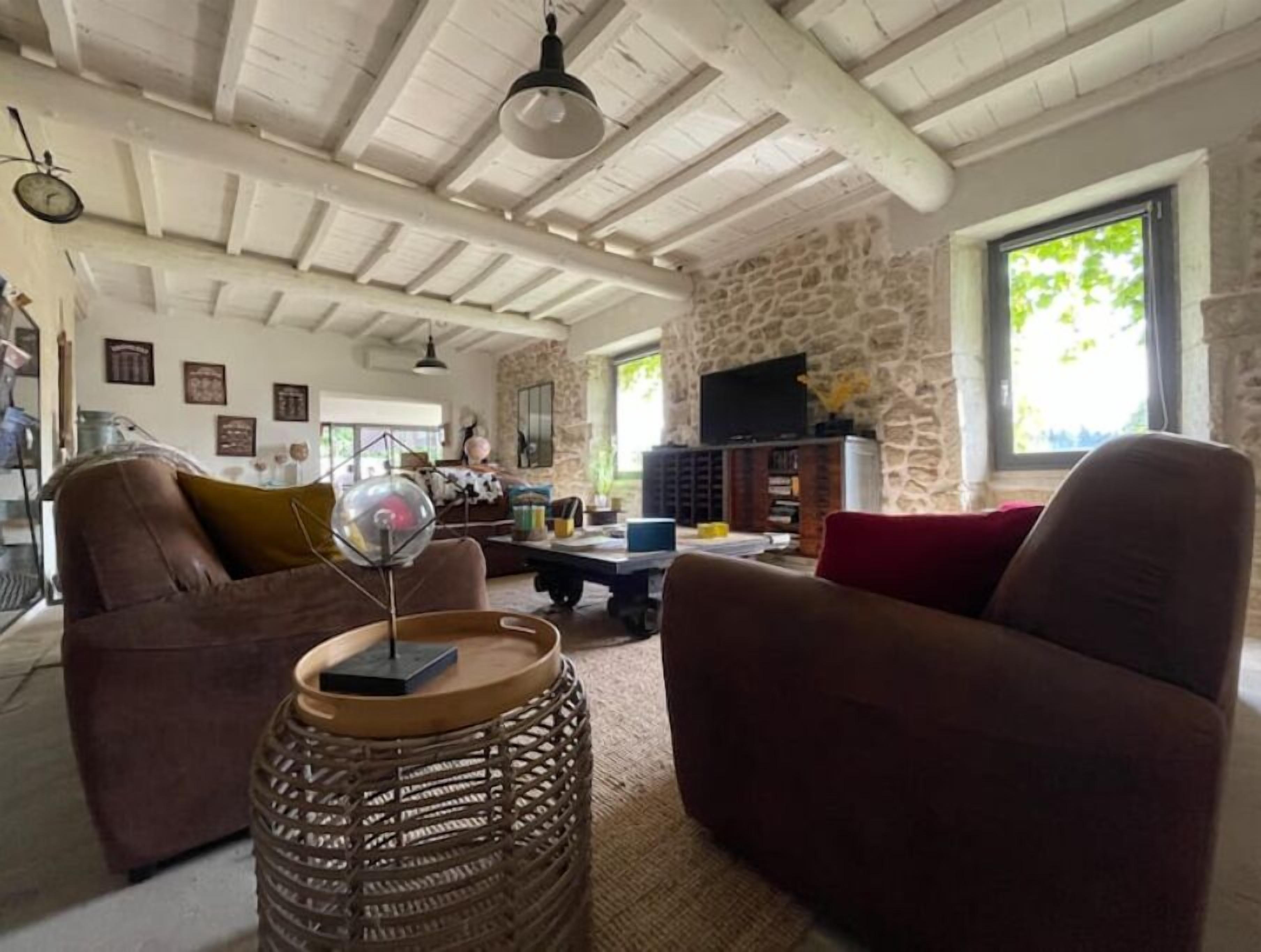 A cozy living room with a stone wall, a television, and a comfortable seating area.