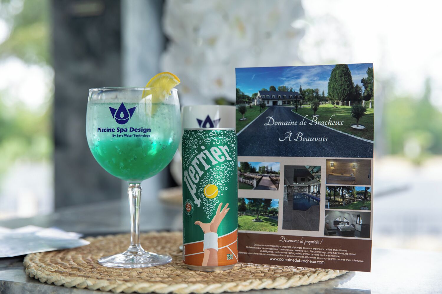 A glass of Perrier water, a brochure for Domaine de Brachieux, and a placemat.