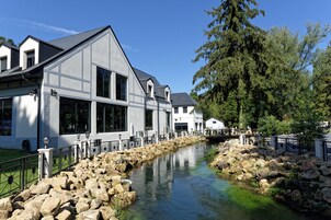 Un edificio moderno con amplias ventanas y un sendero de piedra que conduce a una fuente de agua.