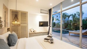 A bedroom with a large bed, a TV, a window with a view of a pool and greenery, and a sliding door with a wooden panel.
