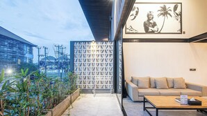 A modern interior with a sofa, coffee table, and a decorative wall with a geometric pattern. - Expansive Loft 200m from Canggu Beach Haven<br>Part of Noma Estate (Pererenan)