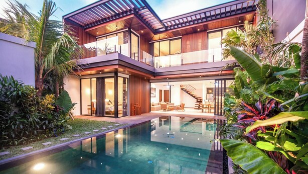 A modern two-story house with a swimming pool, large windows, and outdoor seating. - Chic 4BR, 200m to Canggu's Blissful Beach Haven (Pererenan)