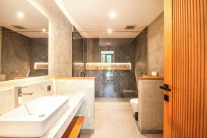 Ein modernes Badezimmer mit einer großen Badewanne, einer separaten Duschkabine und einem WC.
