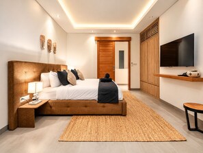 A modern bedroom with a large bed, bedside tables, a TV, and a wardrobe.