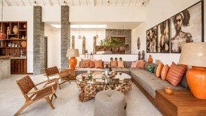 A spacious living area with a sofa, chairs, a coffee table, and a fireplace. - Luxurious 5BR Dream Villa, 200m to Berawa Beach (Canggu)