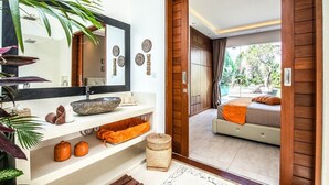 A modern bathroom with a large mirror, stone basin, and shelves with towels. - Splendid 6BR Villa, Just 400m to the Shoreline (Kuta Utara)