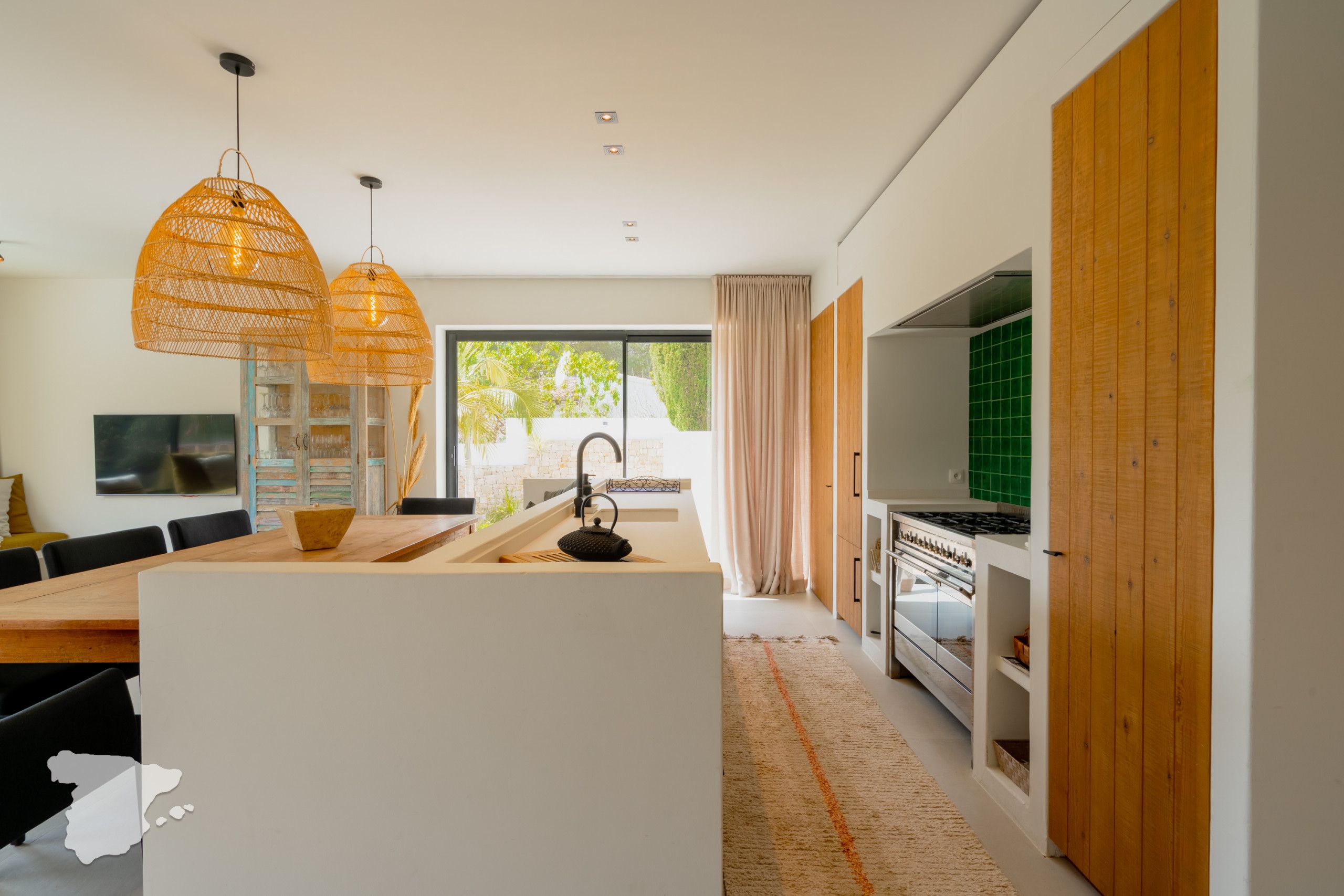 Cozinha moderna com ilha central, armários de madeira e uma janela grande.