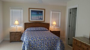 A bedroom with a bed, two bedside tables with lamps, a framed picture on the wall, and a door. - 6 Bedroom with an elevator one house back from the beach! (Bethany Beach)
