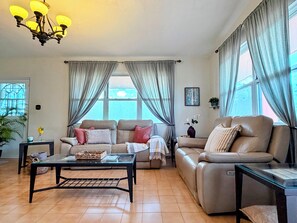 Ein Wohnzimmer mit zwei Sofas, einem Couchtisch und einer Chandelier.