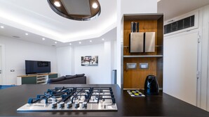 A modern kitchen with a gas stove, a coffee maker, and a knife block on the counter. - Casa del Marchese del Grillo (Rome)