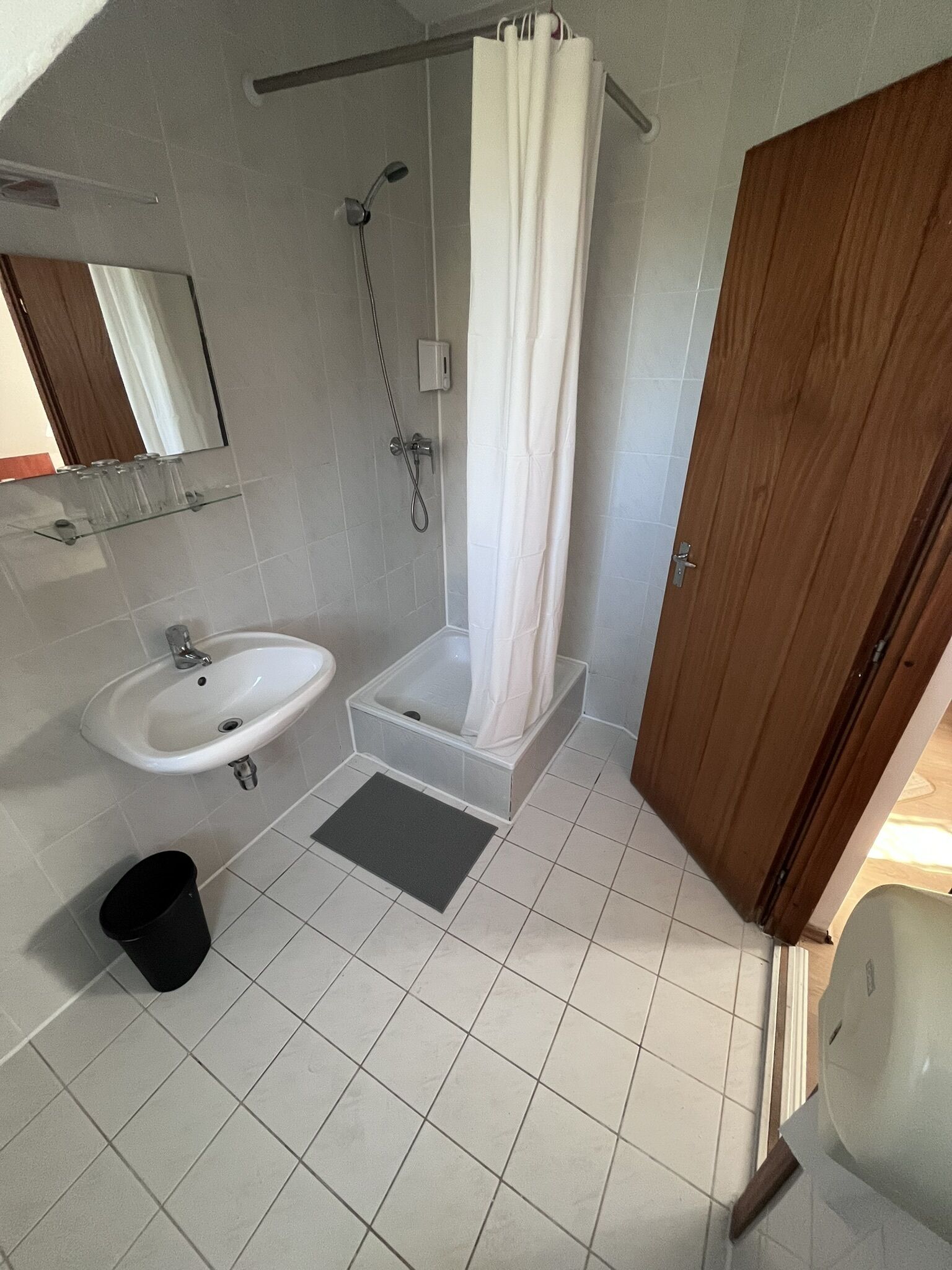 A bathroom with a sink, shower, and toilet.