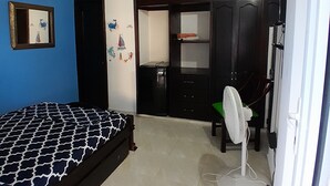 Une chambre à coucher avec un lit, une armoire, un bureau et une chaise.