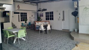 Une pièce avec un sol carrelé, des chaises vertes et blanches, une table et une carte accrochée au mur.
