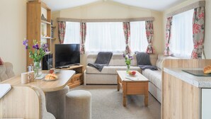 A cozy living area with a sofa, a TV, a coffee table, and a bookshelf.