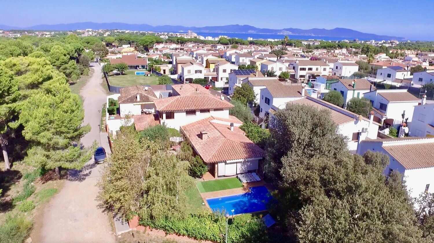 Un quartier résidentiel avec des maisons, une piscine et une vue dégagée sur la mer.