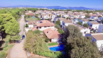Un quartier résidentiel avec des maisons, une piscine et une vue dégagée sur la mer.