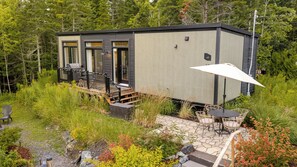 A modern cabin with a deck, outdoor seating, and a patio area. - Plein air & détente au Mont Adstock - Le OLI (Adstock)