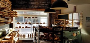 A bakery with various baked goods displayed in glass cases and on shelves.