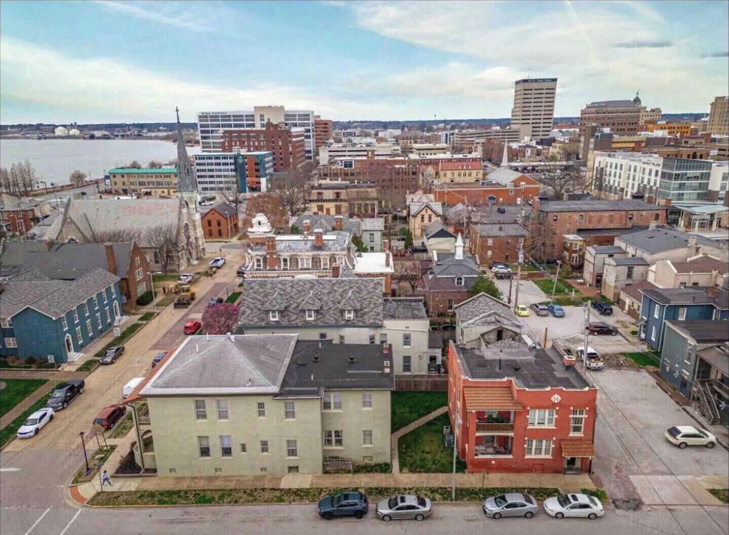 A cityscape with a mix of residential and commercial buildings, including a prominent red building and a large white building with a dome.