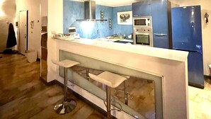 A modern kitchen with a bar area, built-in appliances, and a lofted seating area. - Piazza santa croce, uffizzi, luxury apartment in historic building  (Firenze)